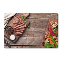 Obraz na płótnie Stek wołowy i grillowane warzywa na desce do krojenia