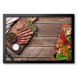 Obraz w ramie Stek wołowy i grillowane warzywa na desce do krojenia