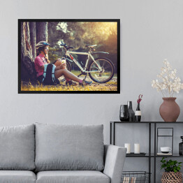 Obraz w ramie Cyklista odpoczywający pod drzewem