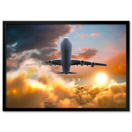 Plakat w ramie Samolot lecący podczas zachodu słońca - widok z dołu