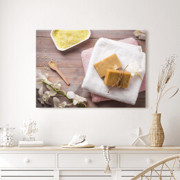 Obraz na płótnie Zestaw spa - naturalne mydło, żółta sól i biała orchidea na drewnianym tle 