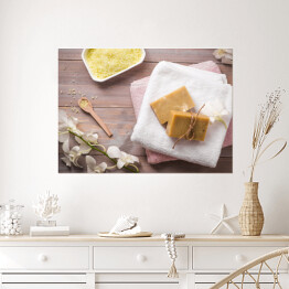 Plakat Zestaw spa - naturalne mydło, żółta sól i biała orchidea na drewnianym tle 