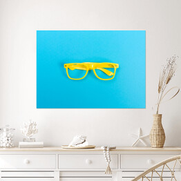 Plakat Para żółtych okularów na jasnoniebieskim tle