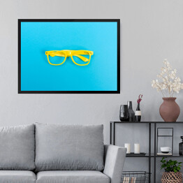 Obraz w ramie Para żółtych okularów na jasnoniebieskim tle