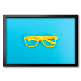 Obraz w ramie Para żółtych okularów na jasnoniebieskim tle