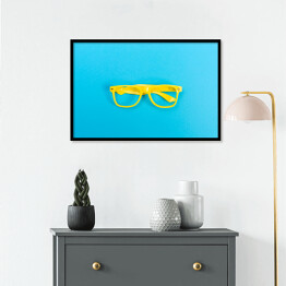 Plakat w ramie Para żółtych okularów na jasnoniebieskim tle