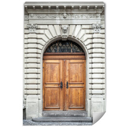 Stare drewniane drzwi w szarej kamiennej ścianie