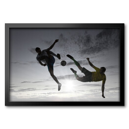 Obraz w ramie Sylwetki dwóch piłkarzy na szarym niebie