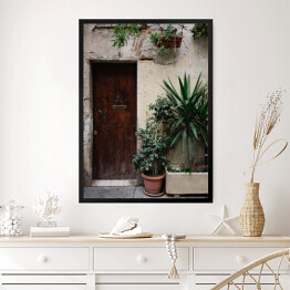 Obraz w ramie Stary dom z roślinami w garnkach i drewnianymi ciemnobrązowymi drzwiami