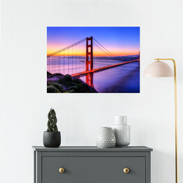 Plakat samoprzylepny Most Golden Gate na tle wody w różowych barwach oraz złocisto błękitnego nieba