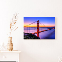 Most Golden Gate na tle wody w różowych barwach oraz złocisto błękitnego nieba