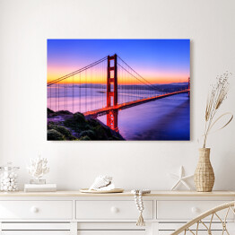 Obraz na płótnie Most Golden Gate na tle wody w różowych barwach oraz złocisto błękitnego nieba