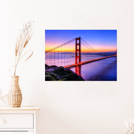 Plakat samoprzylepny Most Golden Gate na tle wody w różowych barwach oraz złocisto błękitnego nieba