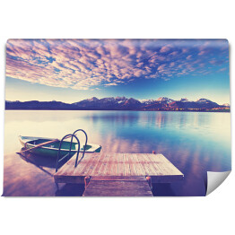 Fototapeta Samotna łódka nad jeziorem w odcieniach różu i fioletu