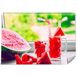 Fototapeta Szklanka ze słomkami i sokiem z arbuza na parapecie