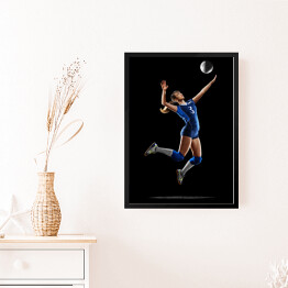 Obraz w ramie Kobieta grająca w siatkówkę na czarnym tle