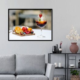 Plakat w ramie Czerwone wino z owocami na stole