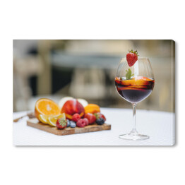 Obraz na płótnie Czerwone wino z owocami na stole