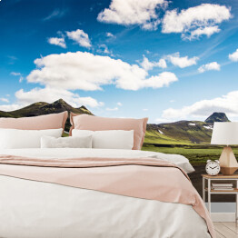 Fototapeta Lato - krajobraz z zieloną górą, chmurami i niebieskim niebem, Islandia