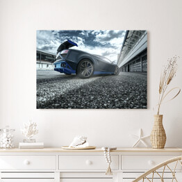 Obraz na płótnie Czarno niebieski sportowy samochód na torze wyścigowym