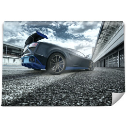 Fototapeta samoprzylepna Czarno niebieski sportowy samochód na torze wyścigowym