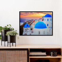 Plakat w ramie Tradycyjne greckie miasteczko Oia na wyspie Santorini z niebieskimi kopułami kościołów