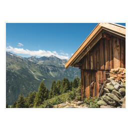 Plakat Drewniana chata na wzgórzu z wysokimi górami w tle