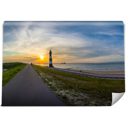 Fototapeta samoprzylepna Długa droga w stronę słońca i latarnia morska, Breskens - Holandia