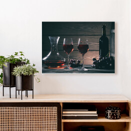 Obraz na płótnie Wino w kieliszkach, karafki i butelki na drewnianym tle