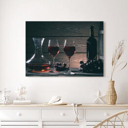 Obraz na płótnie Wino w kieliszkach, karafki i butelki na drewnianym tle