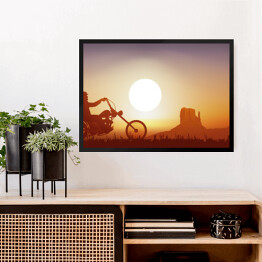 Obraz w ramie Motocyklista na tle zachodu słońca w pomarańczowym i niebieskim odcieniu