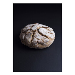 Plakat Okrągły rustykalny francuski chleb pełnoziarnisty z rodzynkami na czarnym tle