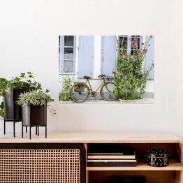 Plakat samoprzylepny Rower przy ścianie wśród roślinności