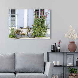 Obraz na płótnie Rower przy ścianie wśród roślinności