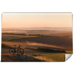 Fototapeta winylowa zmywalna Sylwetka roweru na wzgórzach w trakcie zmierzchu