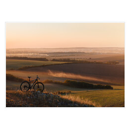 Plakat samoprzylepny Sylwetka roweru na wzgórzach w trakcie zmierzchu