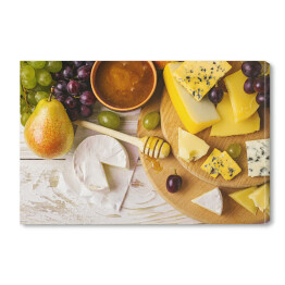 Obraz na płótnie Talerz serowy podawany z miodem, świeżymi winogronami i gruszkami