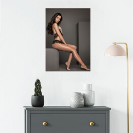 Plakat Atrakcyjna kobieta pozująca siedząc w studiu