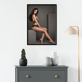 Plakat w ramie Atrakcyjna kobieta pozująca siedząc w studiu