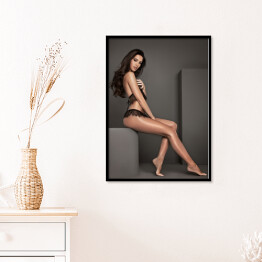 Plakat w ramie Atrakcyjna kobieta pozująca siedząc w studiu