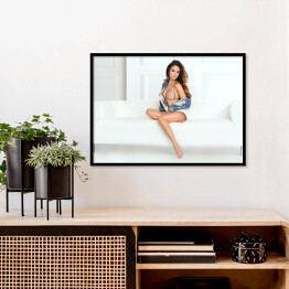 Plakat w ramie Piękna kobieta z długimi nogami pozująca siedząc