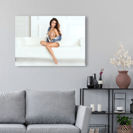 Obraz na płótnie Piękna kobieta z długimi nogami pozująca siedząc