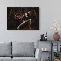 Obraz na płótnie Piękna kobieta z długimi nogami w ciemnym pomieszczeniu
