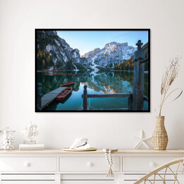 Plakat w ramie Idylliczne górskie jezioro z pomostem i łodziami przed malowniczym skalistym krajobrazem