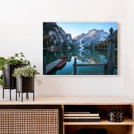 Obraz na płótnie Idylliczne górskie jezioro z pomostem i łodziami przed malowniczym skalistym krajobrazem