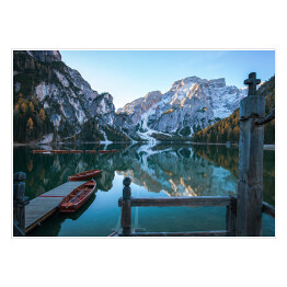 Plakat samoprzylepny Idylliczne górskie jezioro z pomostem i łodziami przed malowniczym skalistym krajobrazem