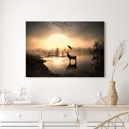 Obraz na płótnie Jeleń na tafli jeziora na tle słońca
