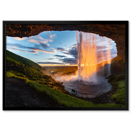 Plakat w ramie Wodospad oświetlony promieniami słonecznymi, widok z jaskini, Islandia