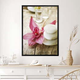 Obraz w ramie Jasne kamienie do masażu i różowy piękny kwiat