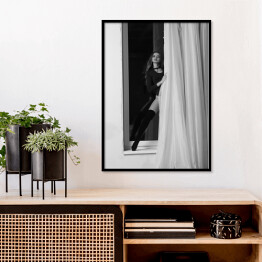 Plakat w ramie Czarno biała fotografia kobiety w oknie